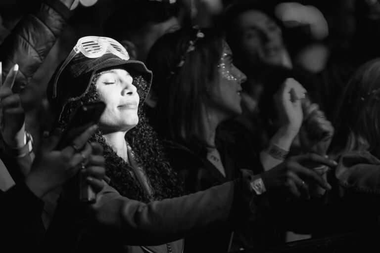 Black and white photograph of a woman in a festival hat with eyes closed, lost in the music at Ibiza Proms, Solihull