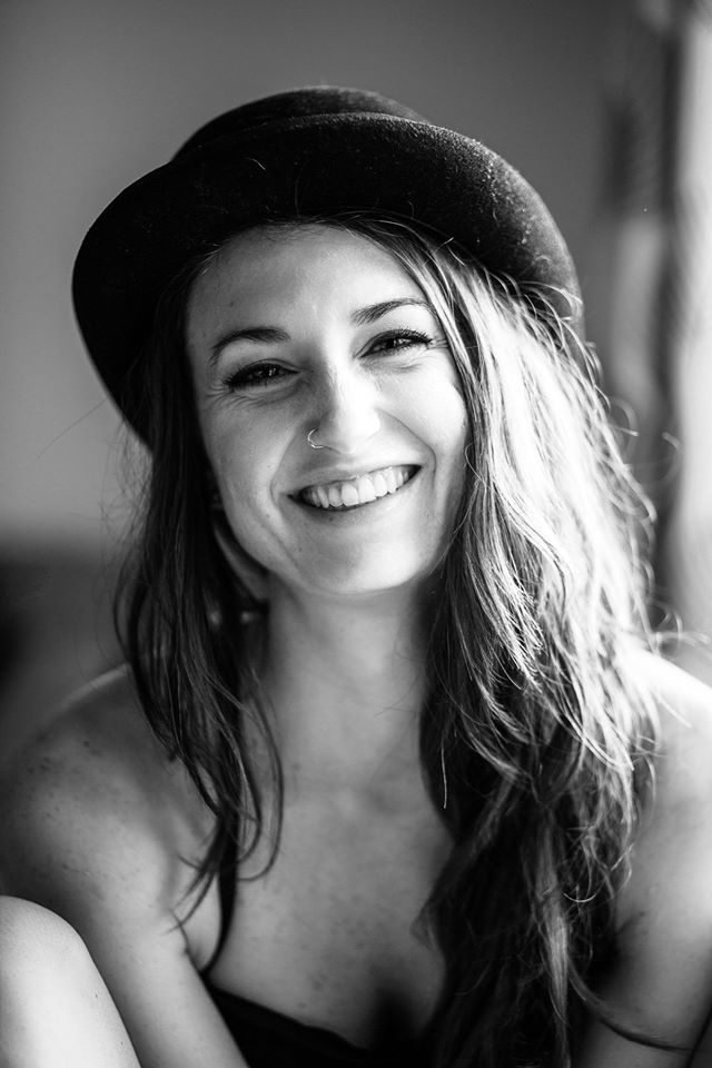 Black and white candid portrait of a laughing woman in a hat