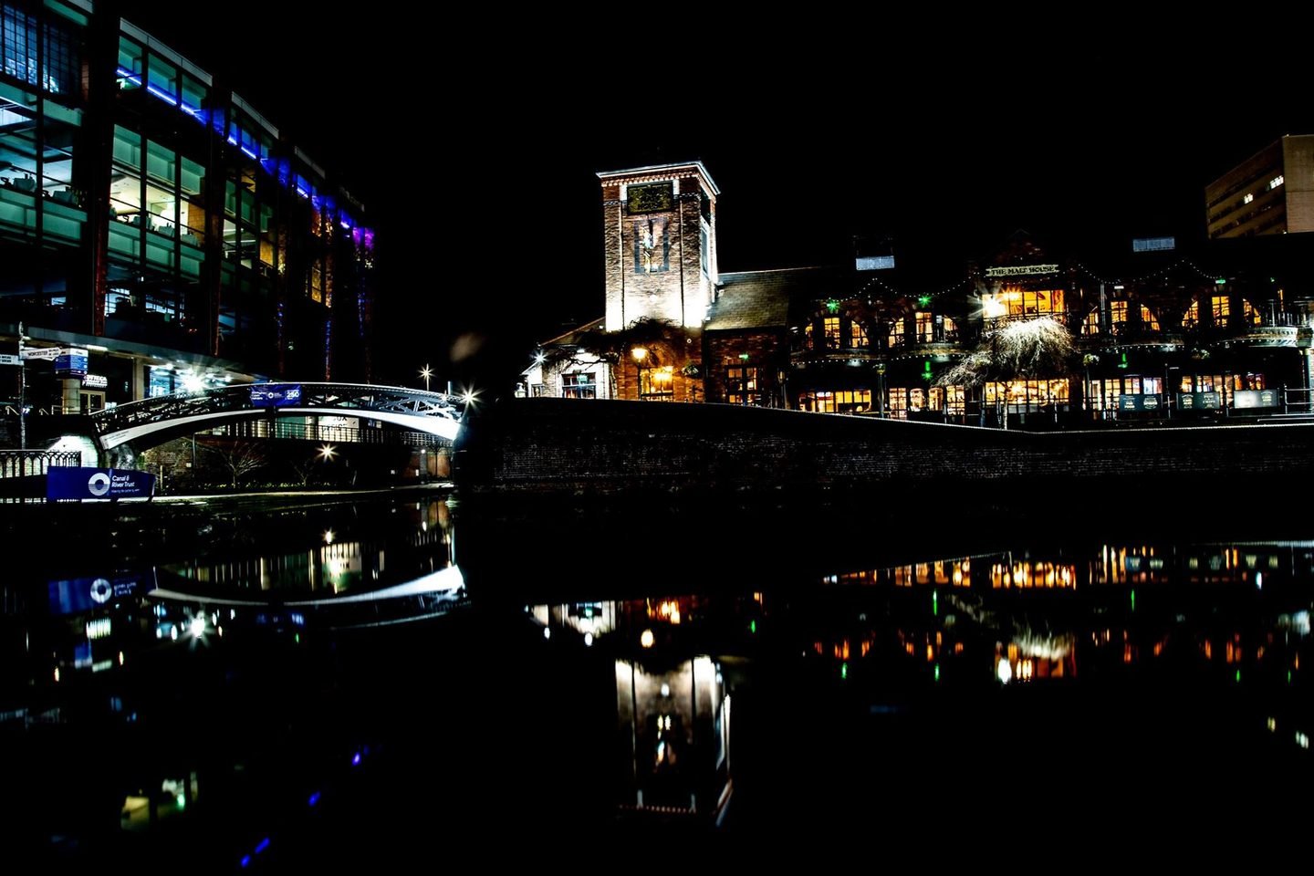 Birmingham canal at night with the Malt House and footbridge reflected in the water