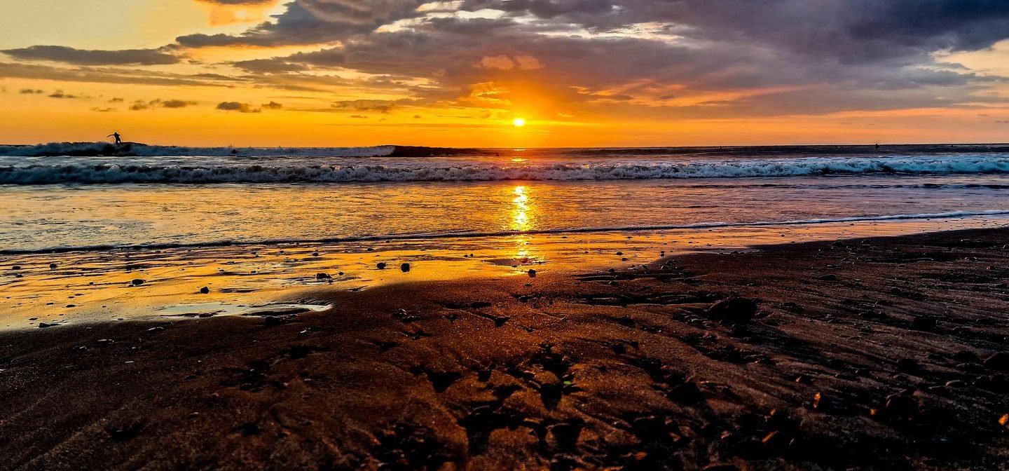 Golden sunset reflected in wet sand on a Costa Rica beach