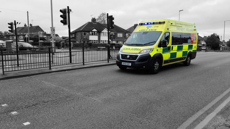 An ambulance in colour against a black and white empty street, Birmingham lockdown 2020