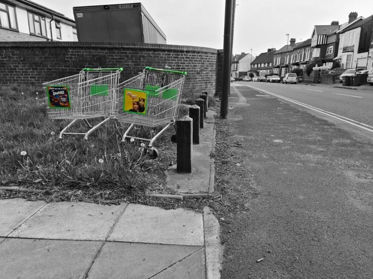 Two abandoned shopping trolleys on a grass verge, Birmingham lockdown 2020