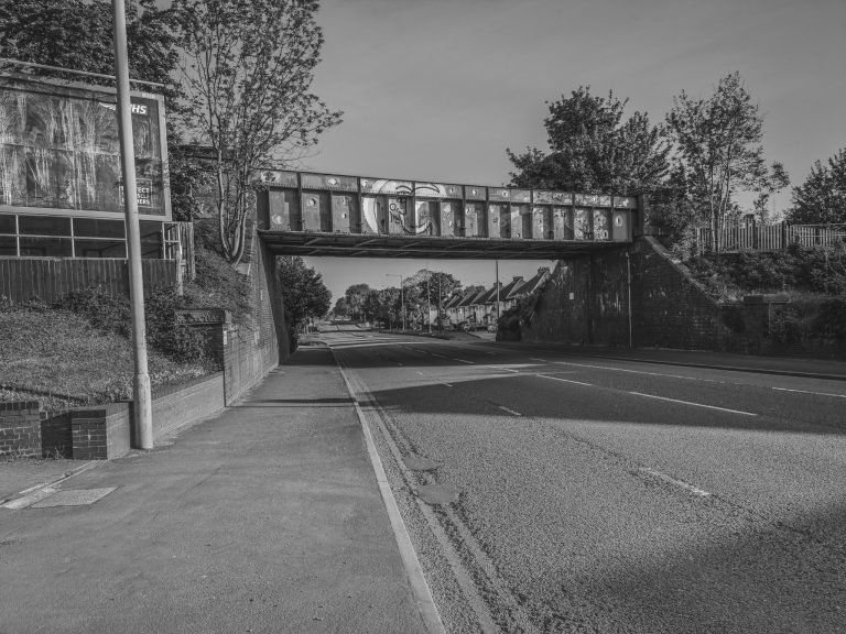 Black and white photograph of an empty road under a railway bridge, Birmingham lockdown 2020