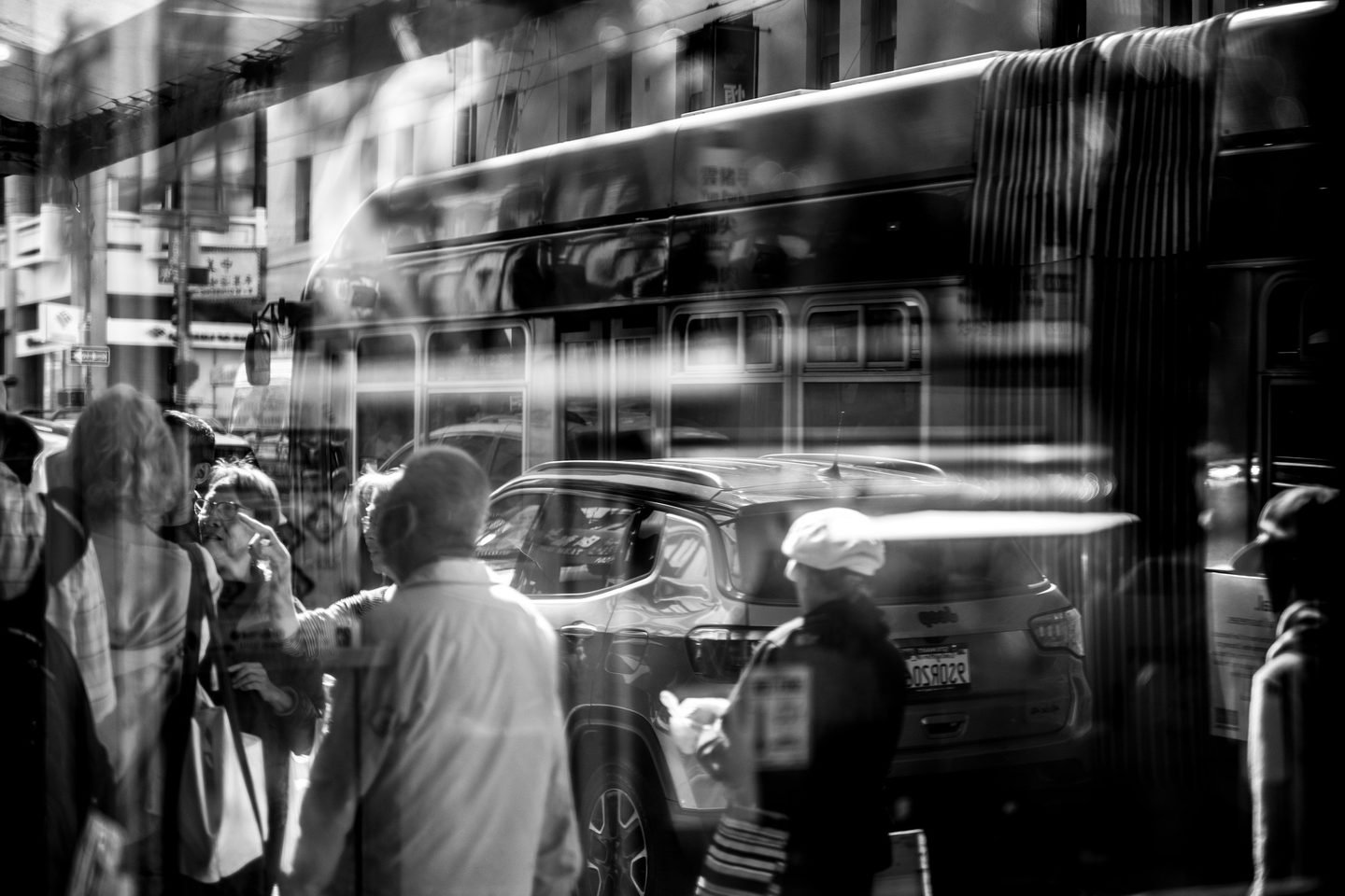 Black and white double exposure of a bus and pedestrians in San Francisco's Chinatown